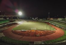 Vista aérea noturna do Estádio Willie Davids, no Brasil, com o campo iluminado e a pista ao redor