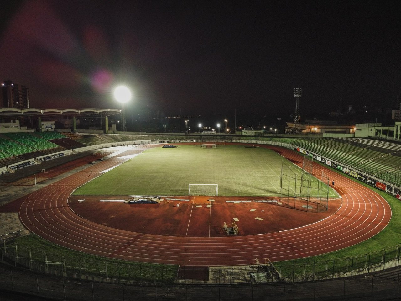 Vista aérea noturna do Estádio Willie Davids, no Brasil, com o campo iluminado e a pista ao redor