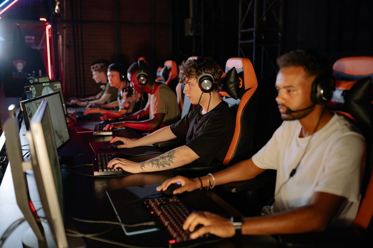 Jogadores concentrados disputam uma partida de esports em um ambiente fechado.