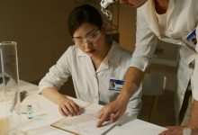 Pesquisadores de jaleco analisam anotações de um estudo científico em laboratório
